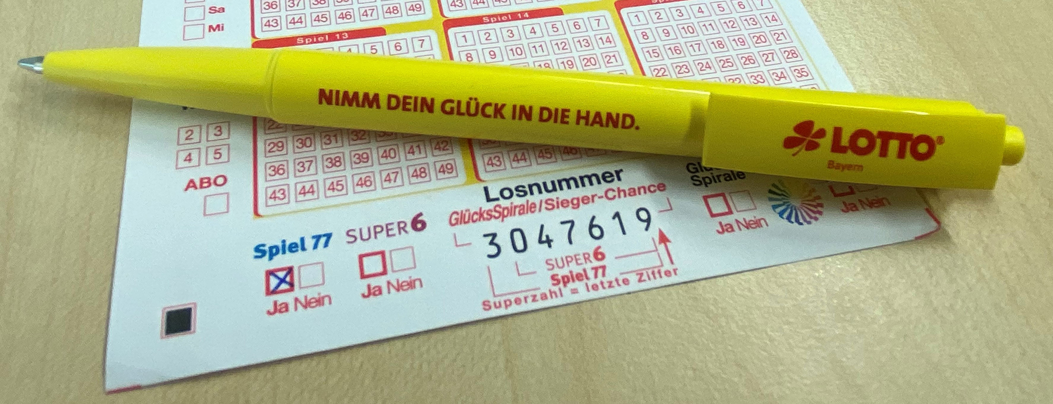 Lottoschein mit Kugeln – Symbolbild für staatlich reguliertes Glücksspiel.