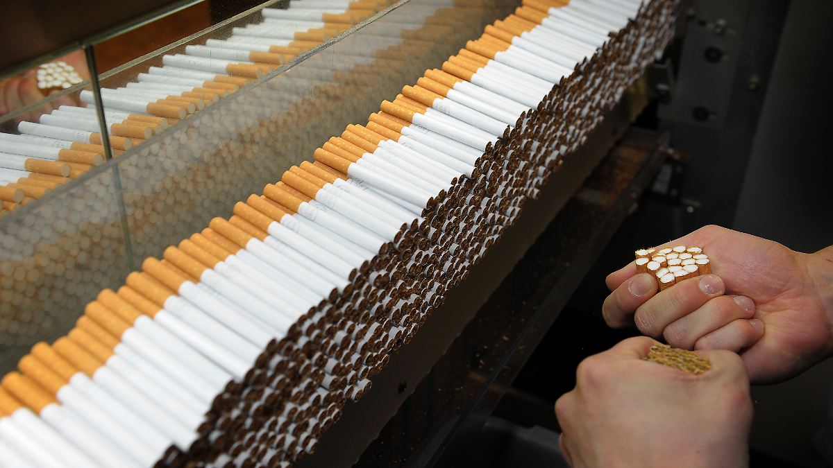 Zigarettenproduktion im Fokus der Kritik an Manipulation durch die Tabakindustrie. Zigaretten auf Förderband – Darstellung industrieller Fertigung im Kontext von Manipulation und Gesundheitsrisiken.