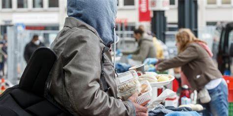 Das Bild zeigt eine Nahaufnahme von Händen mit einer Sparschweinfigur und Kleingeld. Es steht sinnbildlich für finanzielle Herausforderungen, Einkommensschwäche und Vermögensungleichheit in der deutschen Gesellschaft. Die Szene verweist auf die anhaltende Diskussion über Armut und soziale Gerechtigkeit.